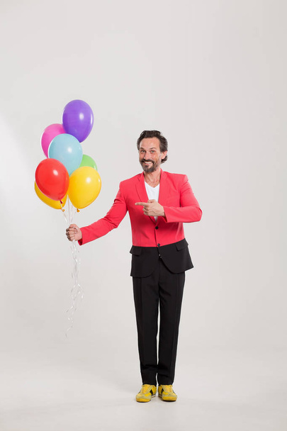 man in red jacket with colorful balloons - Фото, зображення