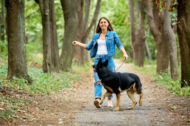 A young girl is walking with a German shepherd dog. - 写真・画像