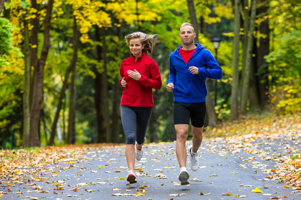 Healthy lifestyle - woman and man running in park - Φωτογραφία, εικόνα