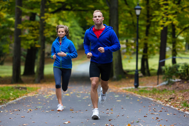 Healthy lifestyle - woman and man running in park - Zdjęcie, obraz