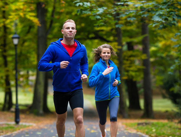 Healthy lifestyle - woman and man running in park - Фото, зображення