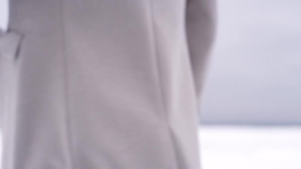Poziomie talii nieczytelna człowieka w brązowy płaszcz obraca umieścić ręką w kieszeni - Materiał filmowy, wideo