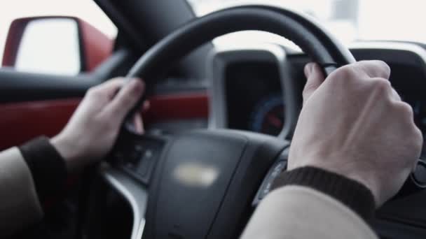 Los brazos del hombre en el volante de conducción de coches caros en día brillante - Metraje, vídeo