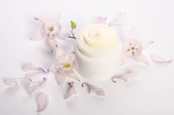 Cute flowers and petal and a jar of natural body cream  - Fotoğraf, Görsel