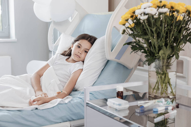 Poor child with drop counter lying on hospital bed - Foto, Bild