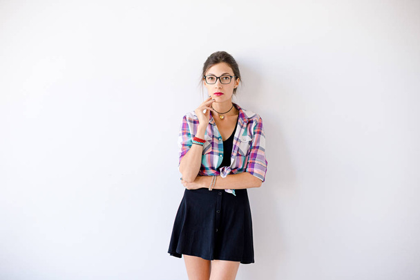 Jonge vrouw dragen van modieuze bril en geruite kleurrijke shirt - Foto, afbeelding