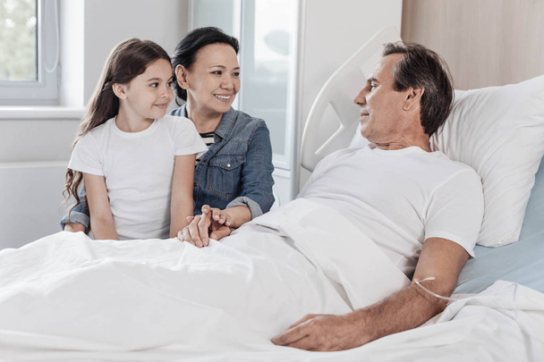 Supportive family visiting their husband and father in hospital - Foto, imagen