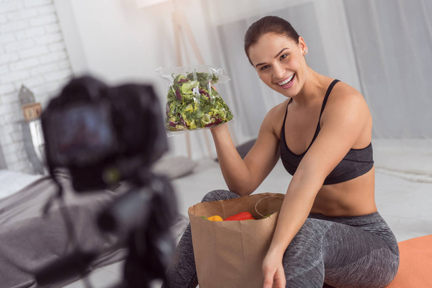 Smiling blogger showing greenery while making a video - Foto, immagini