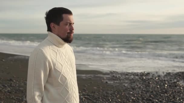 Nuori mies katselee iloiten merimaisemaa, seisoo meren rannalla
 - Materiaali, video