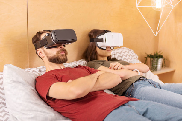 Attractive collected couple watching thriller in VR - Φωτογραφία, εικόνα