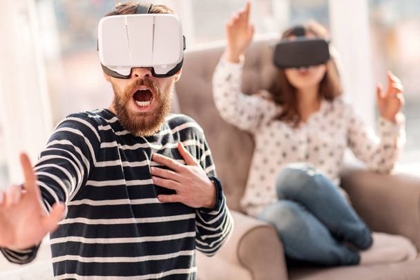 Scared bearded man protecting from VR objects - Φωτογραφία, εικόνα