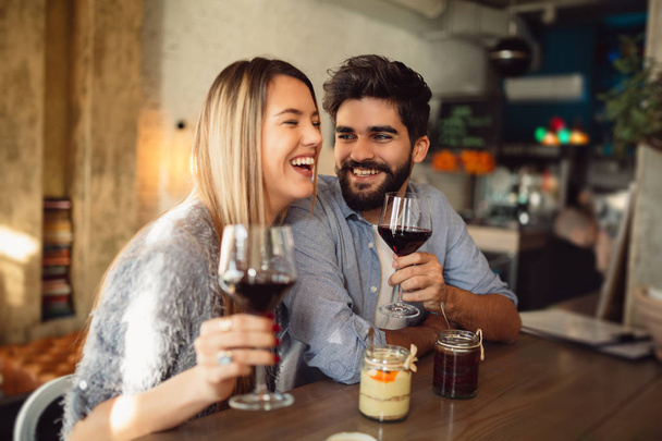Пара в кафе п'є червоне вино
. - Фото, зображення