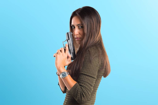 Mujer sosteniendo una pistola
 - Foto, imagen