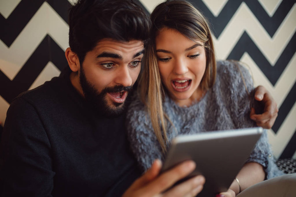 Close-up of shocked couple using tablet. - Photo, Image