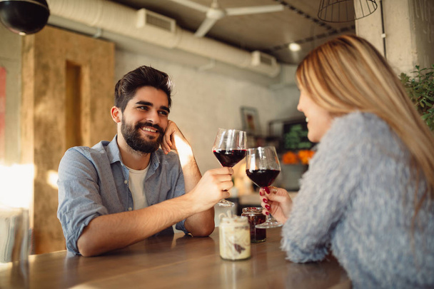 美しいカップル カフェで赤ワインを飲むと、ロマンチックな瞬間を持っていること。カップルの記念日を祝ってまたはバレンタイン. - 写真・画像