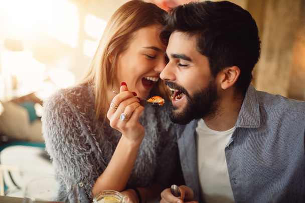 Close-up of a romantic young couple while girl feeding her boyfriend. - Photo, Image