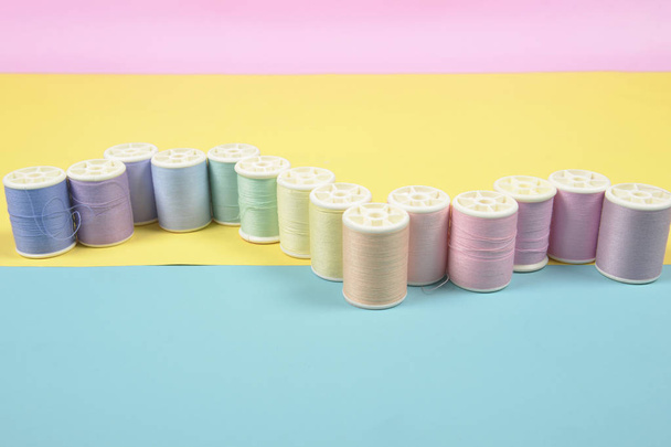 Flat lay of colored thread rolls for sewing on two tone backgrou - Foto, Bild