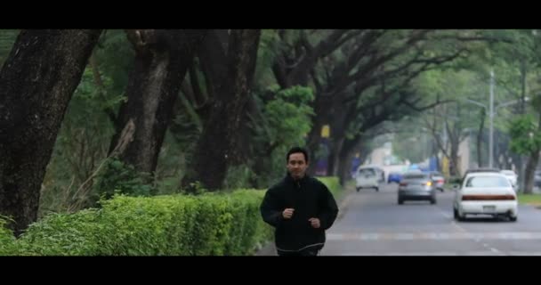 asian running on town street with green environment - Footage, Video