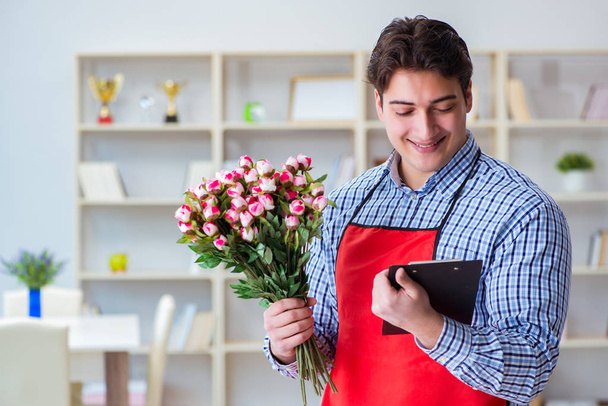 Asistente de floristería ofreciendo un ramo de flores - Foto, Imagen