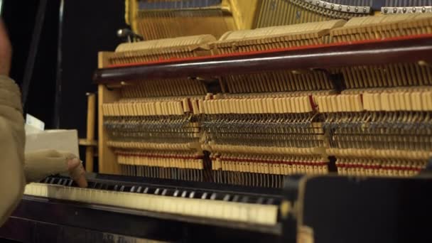 Handen van oude Man in metro ondergrondse spelen Piano met geopend mechanisme og strijkers en hamers - Video