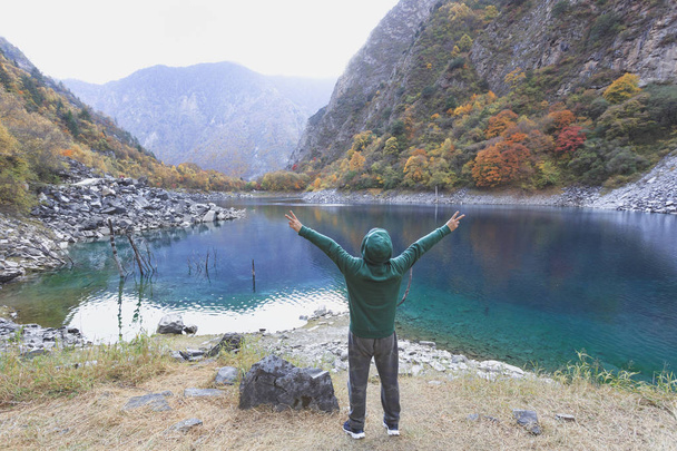 Чоловік у зеленому светрі, що стоїть на озері, натуральний
  - Фото, зображення