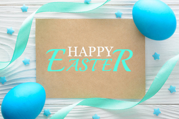Happy Easter greeting card and colorful eggs on the wooden table. Top view - Photo, Image