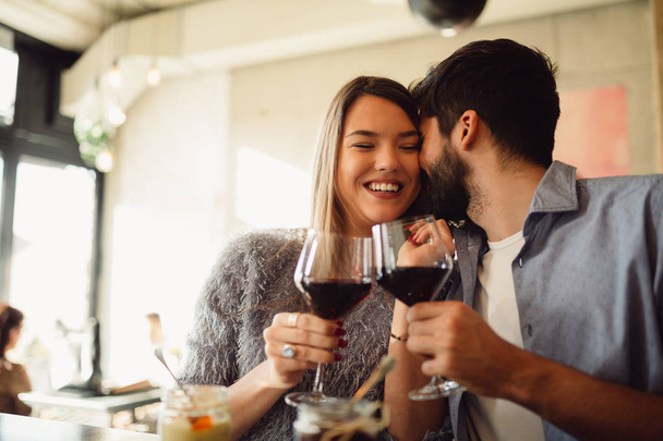 Giovane coppia attraente bere vino rosso. Coppia che celebra anniversario, San Valentino o il giorno della donna internazionale
. - Foto, immagini