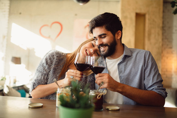 Mladý atraktivní pár, pití červeného vína. Pár slaví výročí, Valentýna nebo den mezinárodní ženské. - Fotografie, Obrázek