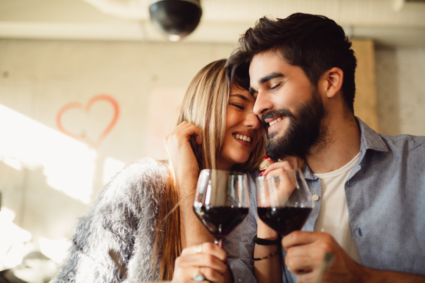 Couple clinking glasses with red wine. Couple celebrating anniversary, Valentine's day or International woman's day. - Foto, imagen