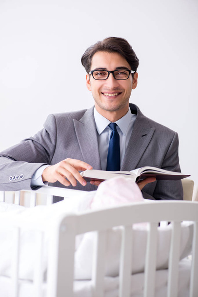 Jonge zakenman probeert te werken vanuit huis zorg na pasgeboren  - Foto, afbeelding