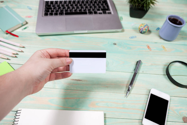 Концепція бізнесу та фінансів. Рука тримає порожні кредитні картки з фоном офісного столу з дерева
 - Фото, зображення