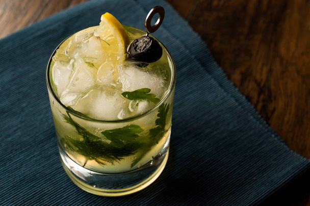 Dillionaire Cocktail with Dill, Gin, Parsley, lemon, Olive and Crushed Ice.  - Photo, image