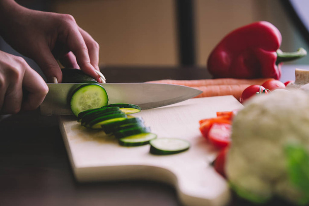 Close up of girl hands while cutting cucumber. - Fotoğraf, Görsel