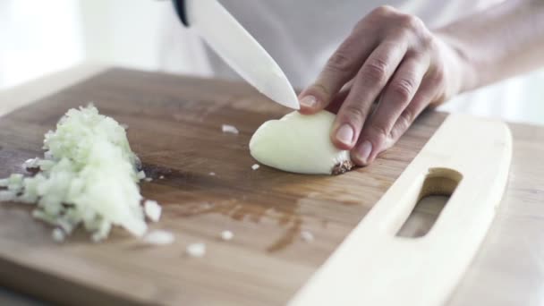 mujer rebanando cebolla en la tabla de cortar en la cocina a cámara lenta
 - Metraje, vídeo