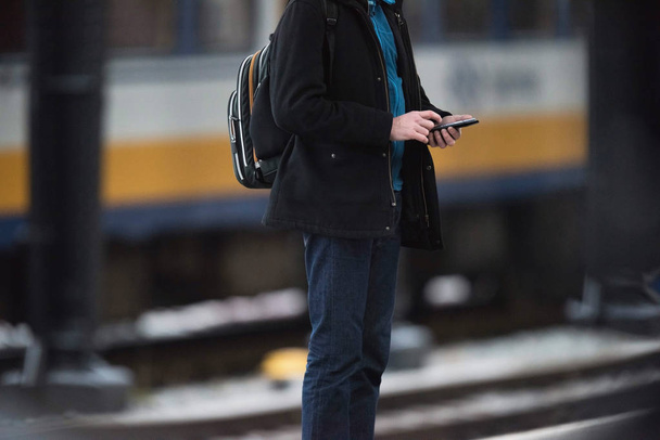 Путешественник с рюкзаком проверки смартфона
  - Фото, изображение