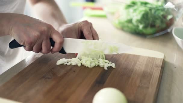Kobieta, krojenie cebuli na desce do krojenia w kuchni zwolnionym tempie - Materiał filmowy, wideo