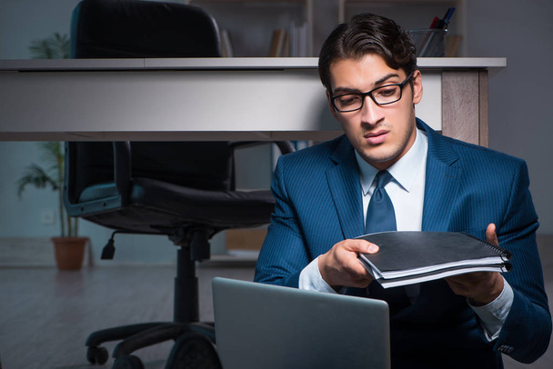 Бизнесмен работает сверхурочно допоздна в офисе - Фото, изображение