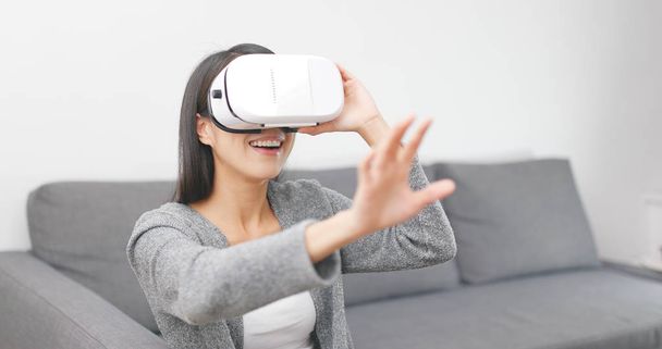 Γυναίκα παίζουν με τη συσκευή εικονικής πραγματικότητας στο σπίτι  - Φωτογραφία, εικόνα