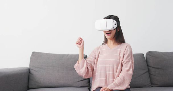 Donna giocare con dispositivo VR a casa
  - Foto, immagini