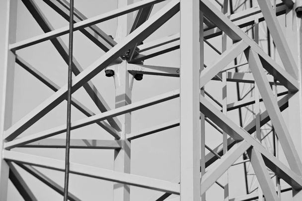 Строительство высотного офисного центра с применением современных технологий. Фрагмент здания на светлом фоне неба. Черное и белое
. - Фото, изображение