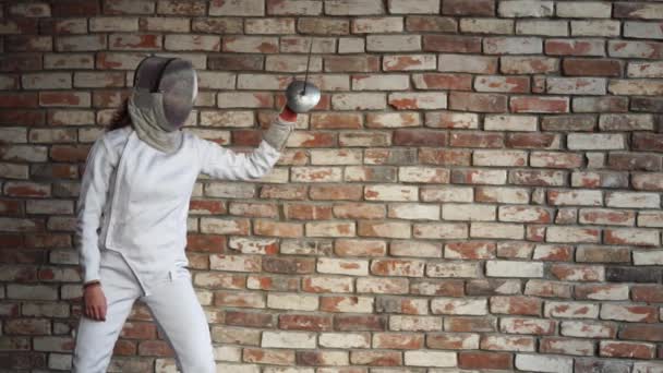Bir kadın koruyucu bir kask içinde profesyonel çit yeteneğini gösterir - Video, Çekim