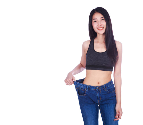 woman shows her weight loss and wearing her old jeans isolated o - Foto, imagen
