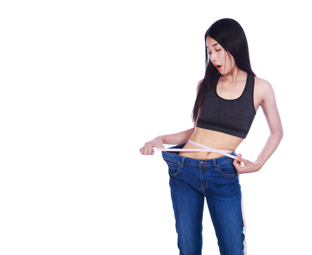 Chocado magro fitness mulher em jeans velhos e fita métrica após
 - Foto, Imagem