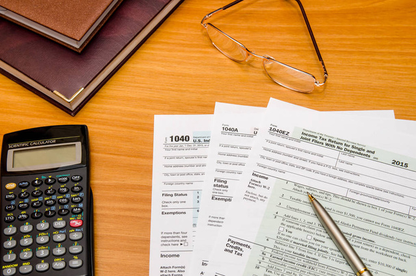 Formulario de declaración de impuestos individual 1040 para 2016 año con gafas y pluma
 - Foto, imagen