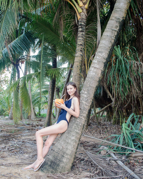 girl drinking cocktail near the palm tree - Фото, зображення