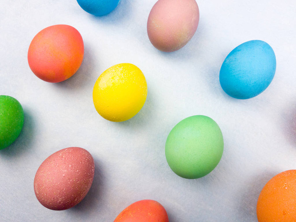 Color easter eggs on pastel blue background. Close up. - 写真・画像