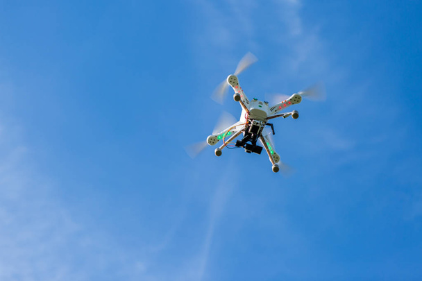 Flug der Drohne in den blauen Himmel, Blick auf die Drohne von unten - Foto, Bild