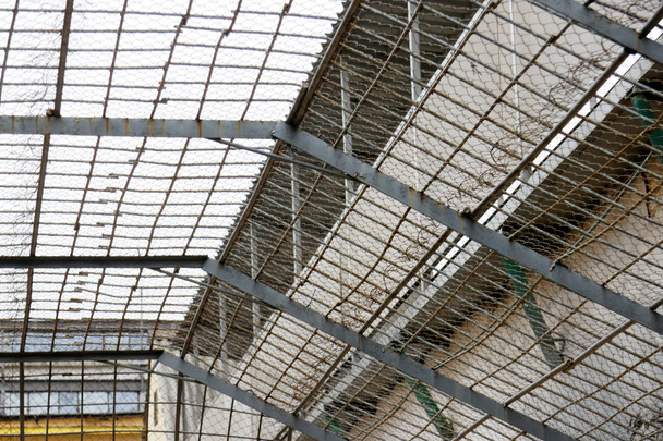 Δικτυωτό πλέγμα πάνω από τους κρατούμενους κοντινή περιοχή στη φυλακή - Φωτογραφία, εικόνα