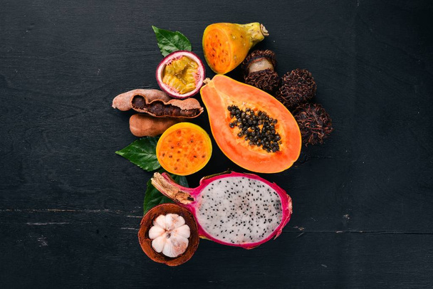 Papaya, Dragon Fruit, Cactus Fruit. Fresh Tropical Fruits. On a wooden background. Top view. Copy space. - 写真・画像