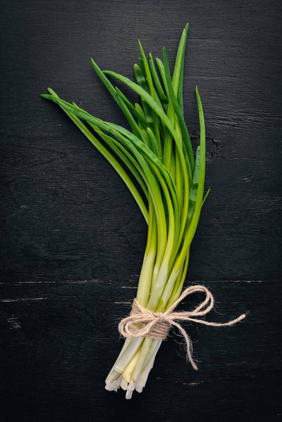 Fresh green onion on a wooden background. Top view. Free space for your text. - Фото, зображення